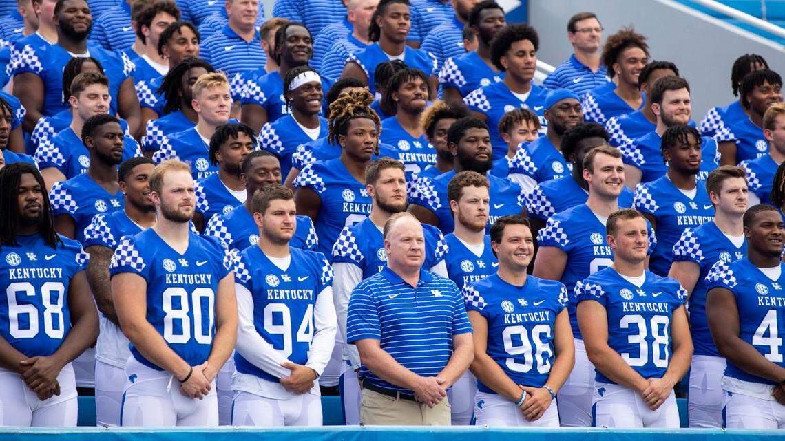 Kentucky head coach Mark Stoops poses with the team for a group picture during the UK Football Media Day at Kroger Field in Lexington, Ky., Wednesday, August 3, 2022.