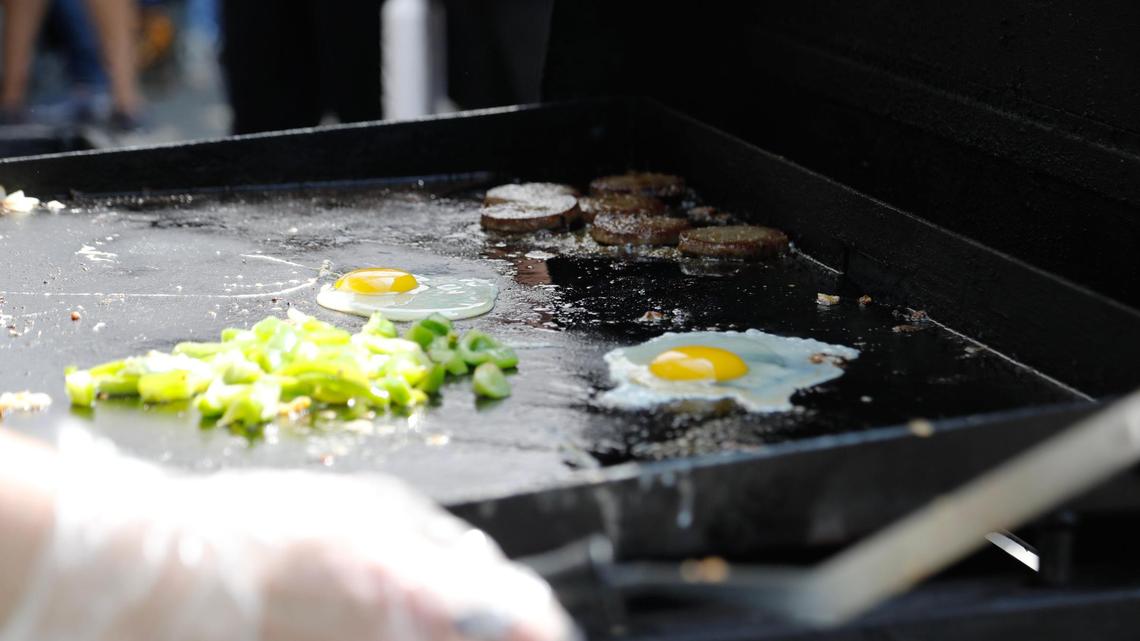 Food cooks on a grill on Saturday, June 24, 2023 at Fifth Third Pavilion in Lexington, Ky. Vendors at the Lexington Farmers Market sometimes sell breakfast sandwiches and other items.