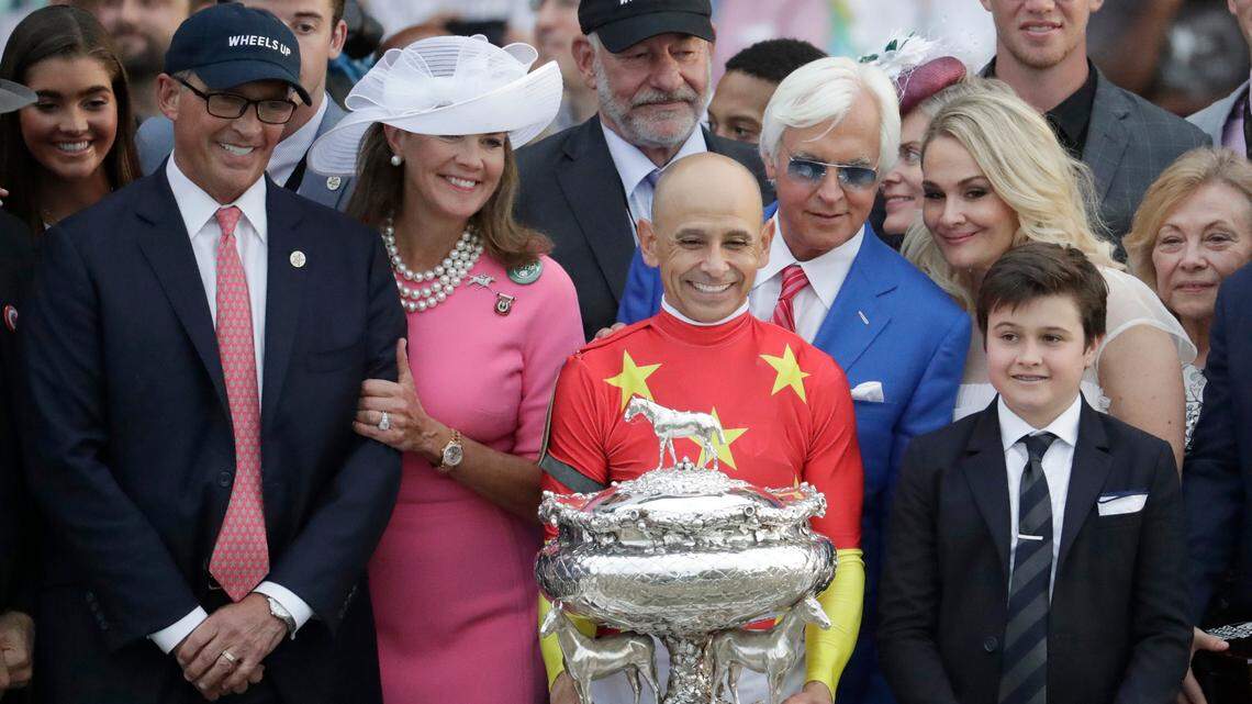 Co-owner Kenny Trout, left, celebrated with jockey Mike Smith, holding the August Belmont trophy, and trainer Bob Baffert, in blue jacket, after Justify became the 13th Triple Crown winner.