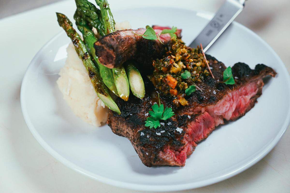 The 28 day dry-aged bone-in ribeye steak, cooked medium-rare, from Salt & Vinegar.