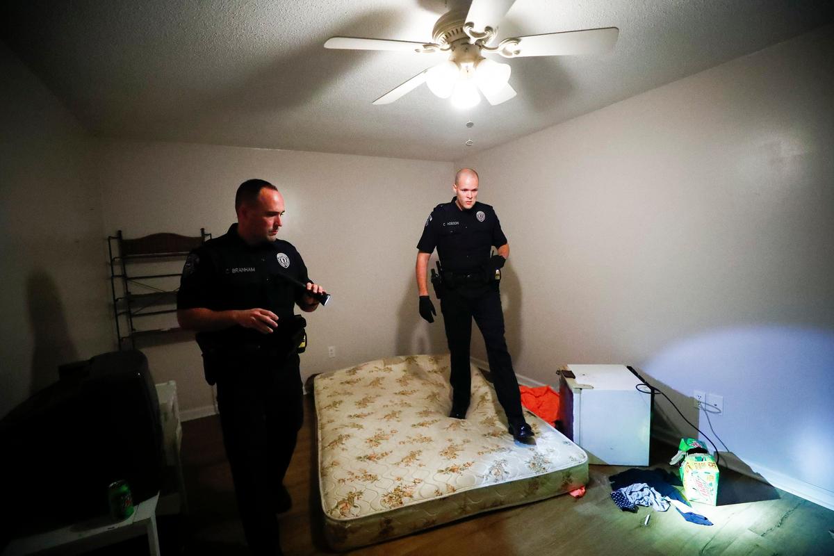 Pikeville Police Sgt. Chad Branham, of Pikeville, Ky., left, and Patrolman Colby Hobson, of Virgie, Ky., search a house on Lancelot Court while serving a warrant in Pikeville, Thursday, Aug. 8, 2019. Upon arrival to the house three people were arrested for meth-related offenses.