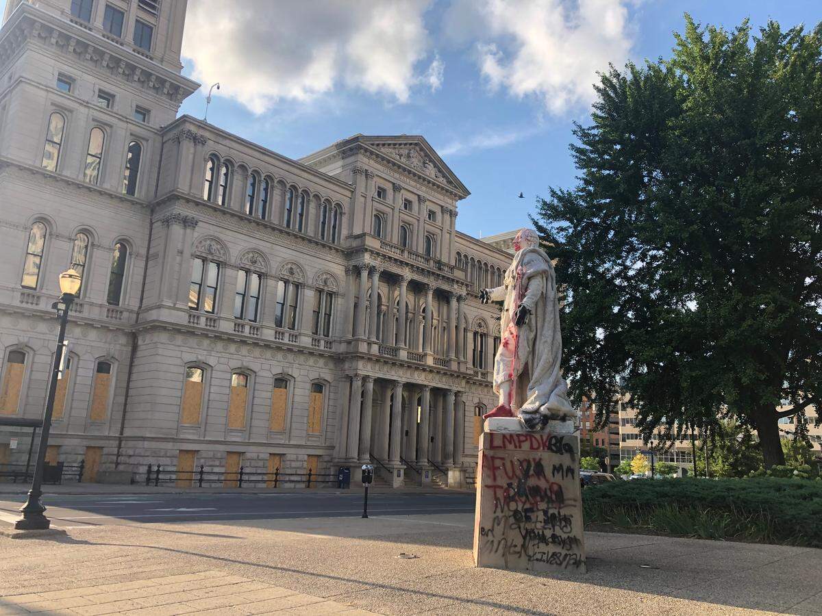 Windows are boarded up at City Hall in downtown Louisville and a statue of King Louis XVI has been vandalized on Wednesday August 26, 2020