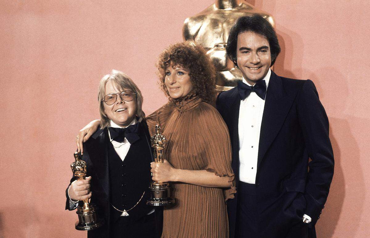 Barbra Streisand with Paul Williams, both holding Oscars they won at the 49th Academy Awards Presentations in the Los Angeles Music Center on March 28, 1977. Barbra sang her song, "Evergreen," from "A Star Is Born," and then accepted the Oscar for best original song. She wrote the music and the lyrics were written by Paul Williams. They are pictured with singer Neil Diamond , who presented the Oscars. 