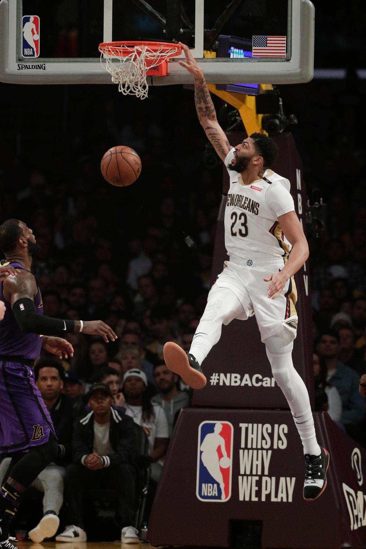 The Pelicans’ Anthony Davis dunked as the Lakers’ LeBron James watched during the first half Friday night in Los Angeles.