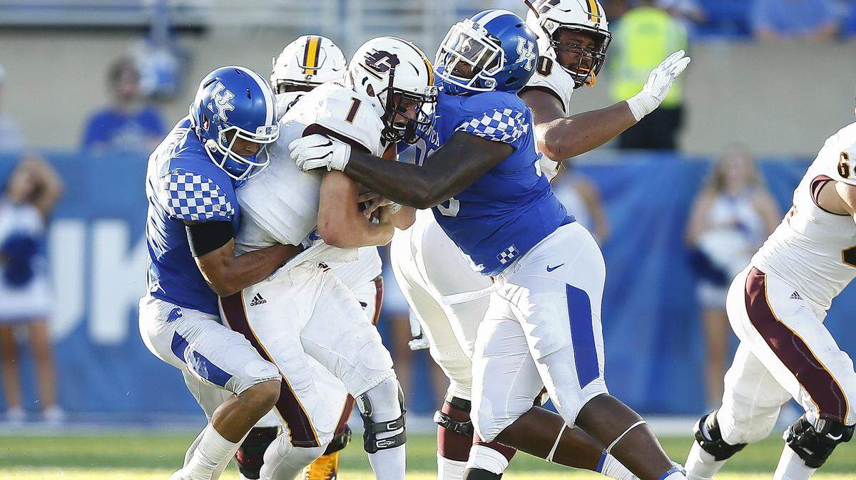 Kentucky defensive tackle Tymere Dubose, right, and linebacker Jordan Jones brought down Central Michigan quarterback Tony Poljan in Saturday’s 35-20 UK victory on Saturday. Dubose had three tackles, including two for loss in the win.