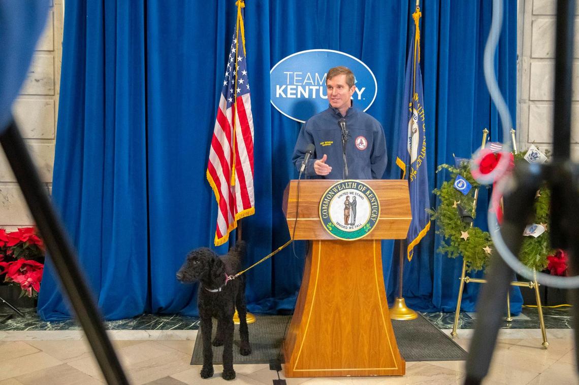 Kentucky Gov. Andy Beshear brought his dog, Winnie, as he speaks to the media before donating blood in the Kentucky state Capitol on Friday, Dec. 17, 2021, in the wake of last weekend’s historic tornado storms in Western Kentucky.