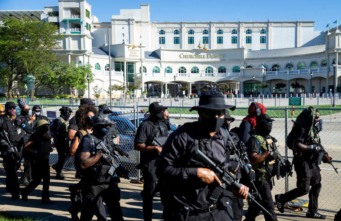 Members of the militia group known as the NFAC stand in front of the entrance to Churchill Downs before the running of Kentucky Derby 146 in Louisville, Ky., Saturday, September 5, 2020. The last time the militia marched through Louisville some of their members was injured after an accidental shooting.