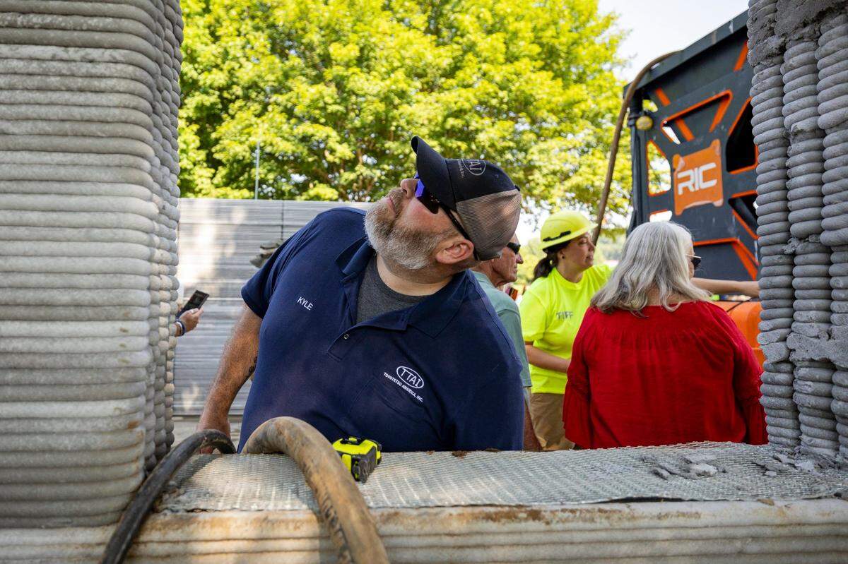 Kyle Roberts inspects the structure, Floodbuster 1, a 3D-printed concrete structure, on Friday, June 27, 2025, at the Somerset Community College Valley Oak Center in Somerset, Ky.