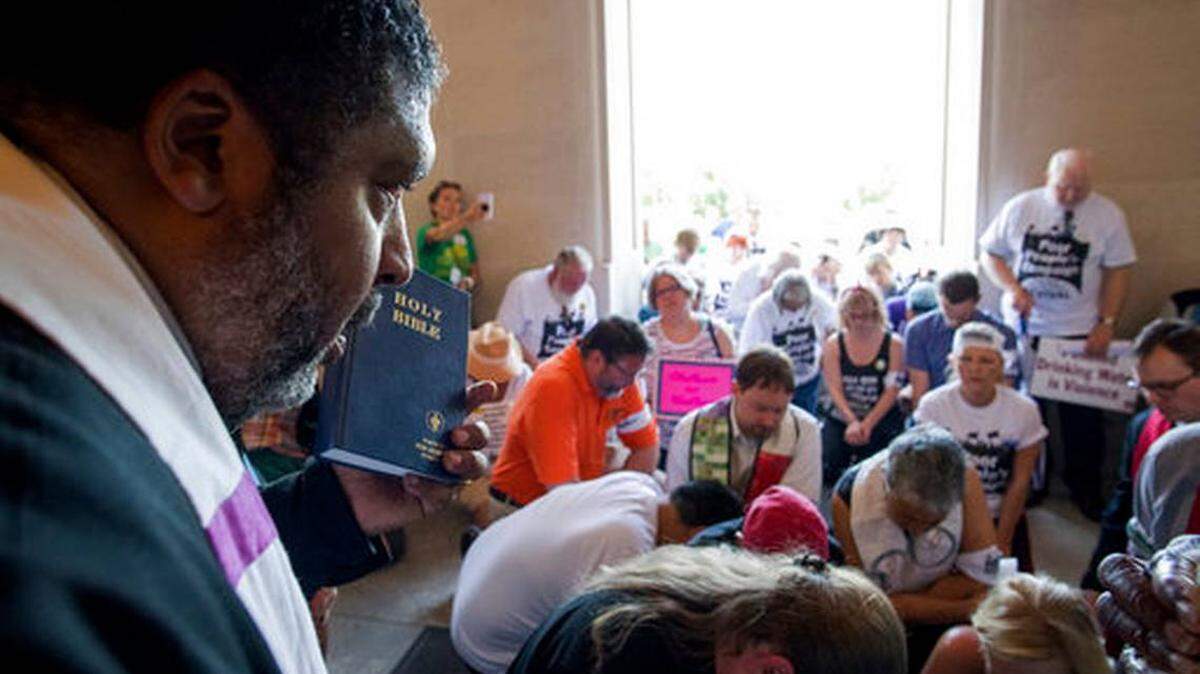 The Rev. William J. Barber prays with protesters after the group was denied access into the state Capitol building during a protest organized by Kentucky Poor People's Campaign in Frankfort Monday.