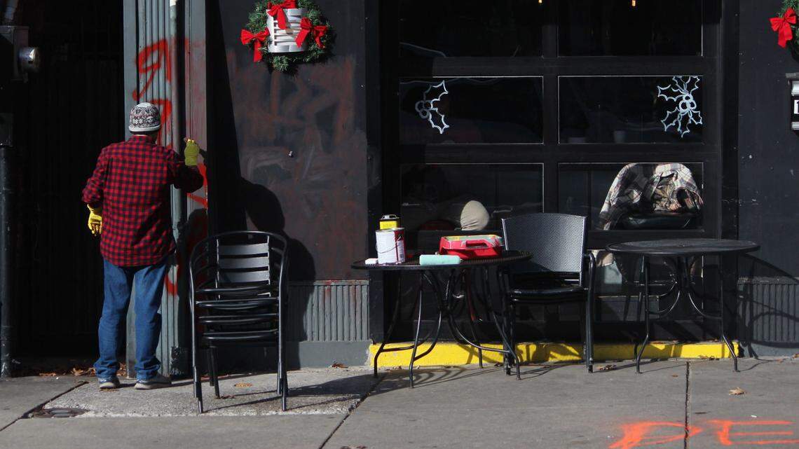 Graffiti on the front of Crossings Lexington, a popular gay bar in downtown Lexington, is cleaned off after someone vandalized the bar. Crossings was one of two downtown businesses to be vandalized, officials say.