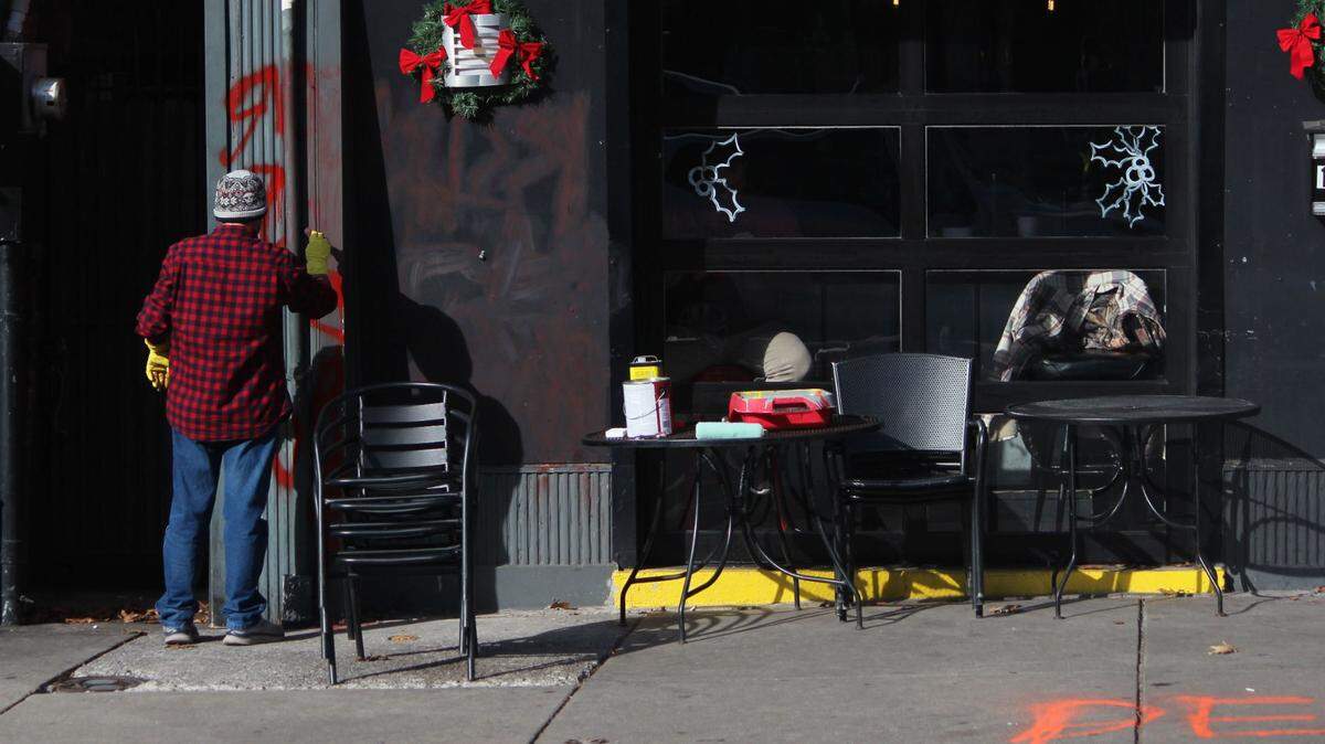 Graffiti on the front of Crossings Lexington, a popular gay bar in downtown Lexington, is cleaned off after someone vandalized the bar. Crossings was one of two downtown businesses to be vandalized, officials say.