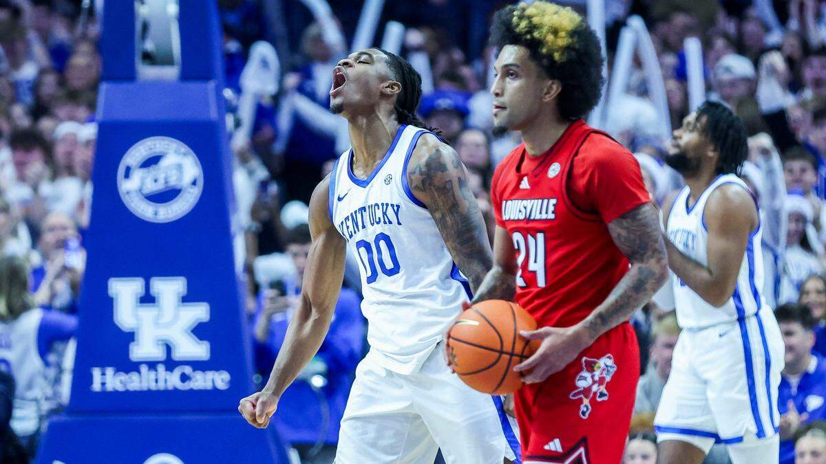 Kentucky guard Otega Oweh (00) celebrates after a first-half dunk as Louisville guard Chucky Hepburn (24) watches during Saturday’s game at Rupp Arena.