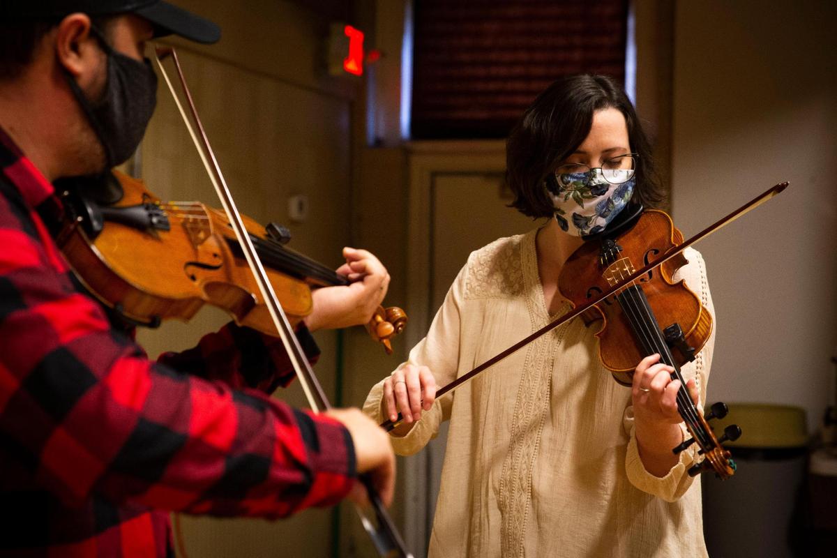 Carrie Wells, right, and her brother, Jesse, tune their fiddles prior to the taping of Red Barn Radio’s Christmas special, An Appalachian Christmas, in Lexington, Ky., on Wednesday, Dec. 2, 2020.