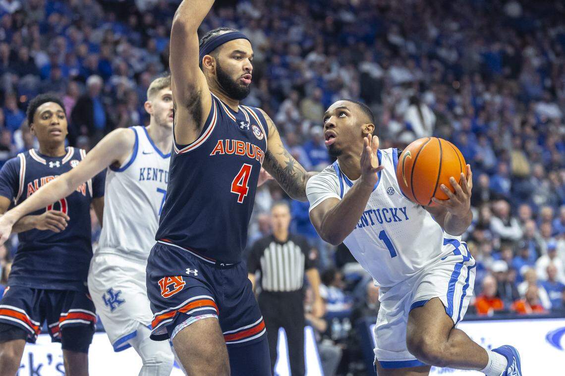 Kentucky guard Lamont Butler (1) drives the ball as Auburn forward Johni Broome (4) defends during a game at Rupp Arena on March 1.