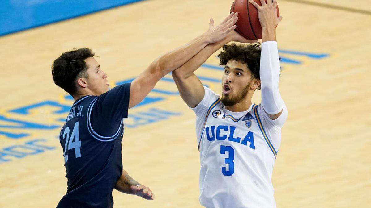 UCLA guard Johnny Juzang, right, is fouled by San Diego guard Chris Herren Jr. during the second half of an NCAA college basketball game Wednesday, Dec. 9, 2020, in Los Angeles. Juzang scored 32 points in the Bruins’ win on Feb. 12, 2021. (AP Photo/Ashley Landis)