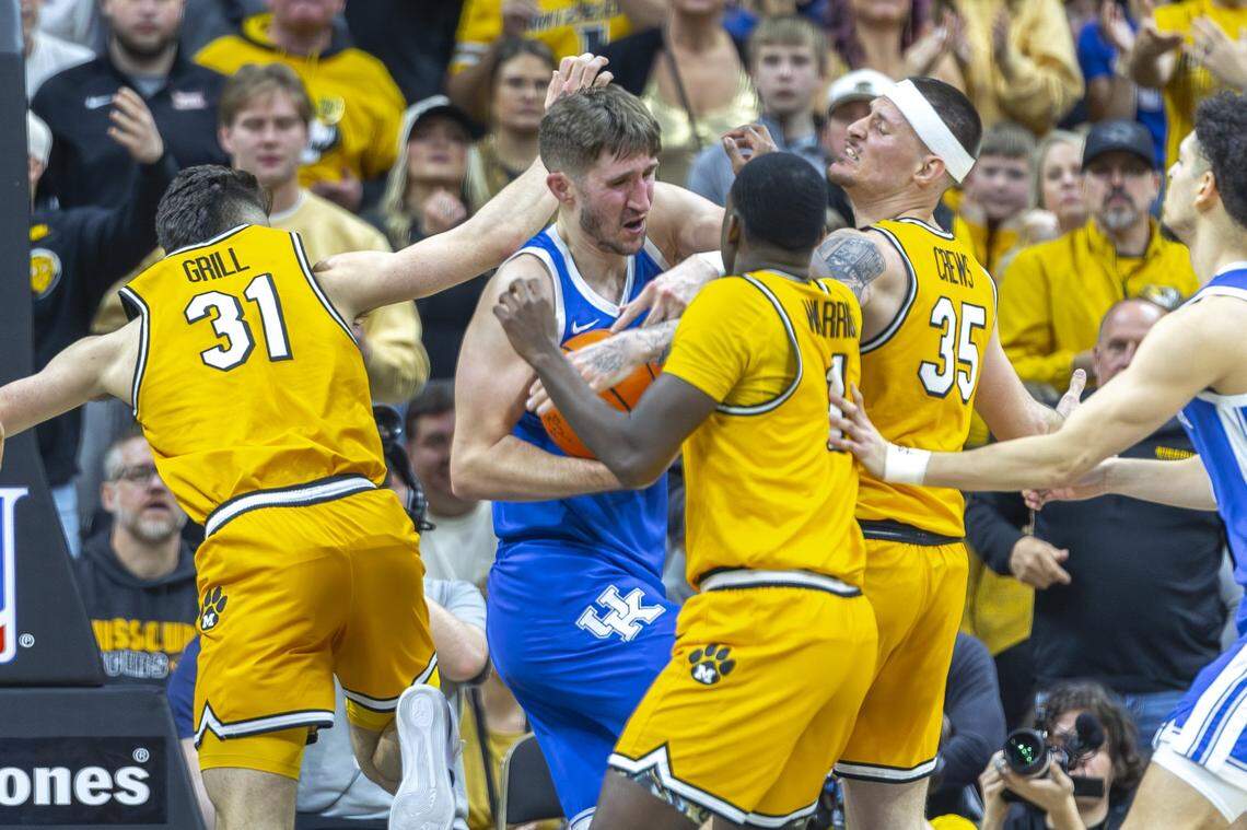 Kentucky forward Andrew Carr, center, grabs a loose ball in front Missouri Tigers guards Marques Warrick (1) and Jacob Crews (35) during Saturday’s game.