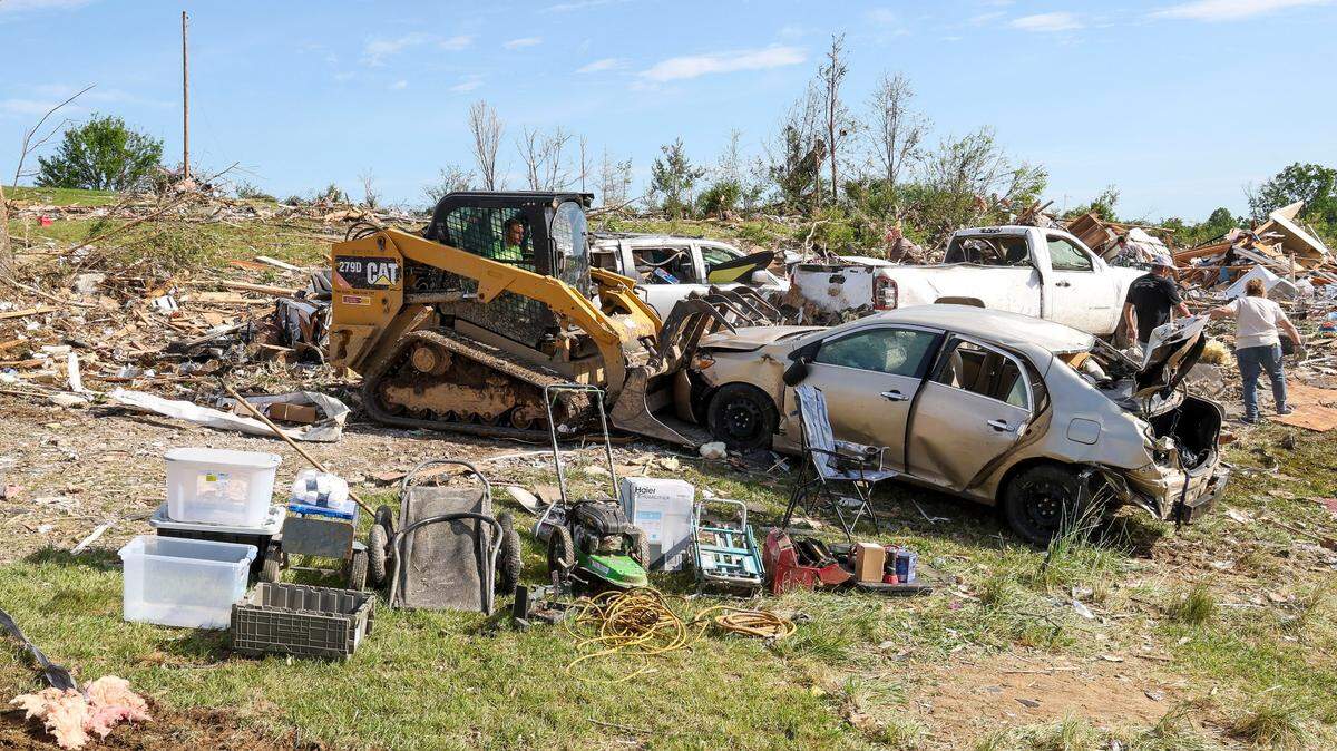 Melvin Brock removes a car as saved items sit in front of the destroyed Sunshine Hills neighborhood home of David and Edwina Wilson, Sunday, May 18, 2025 in London, Ky. Two days earlier, a deadly tornado ripped through the neighborhood destroying homes.