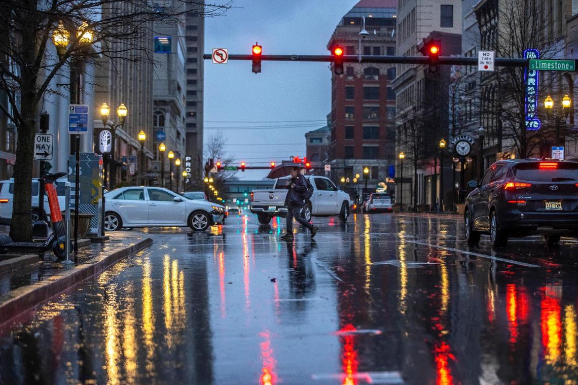 Will Carroll of Lexington crosses East Main Street during a rain storm in downtown Lexington, Ky., on Thursday, Jan. 12, 2023.