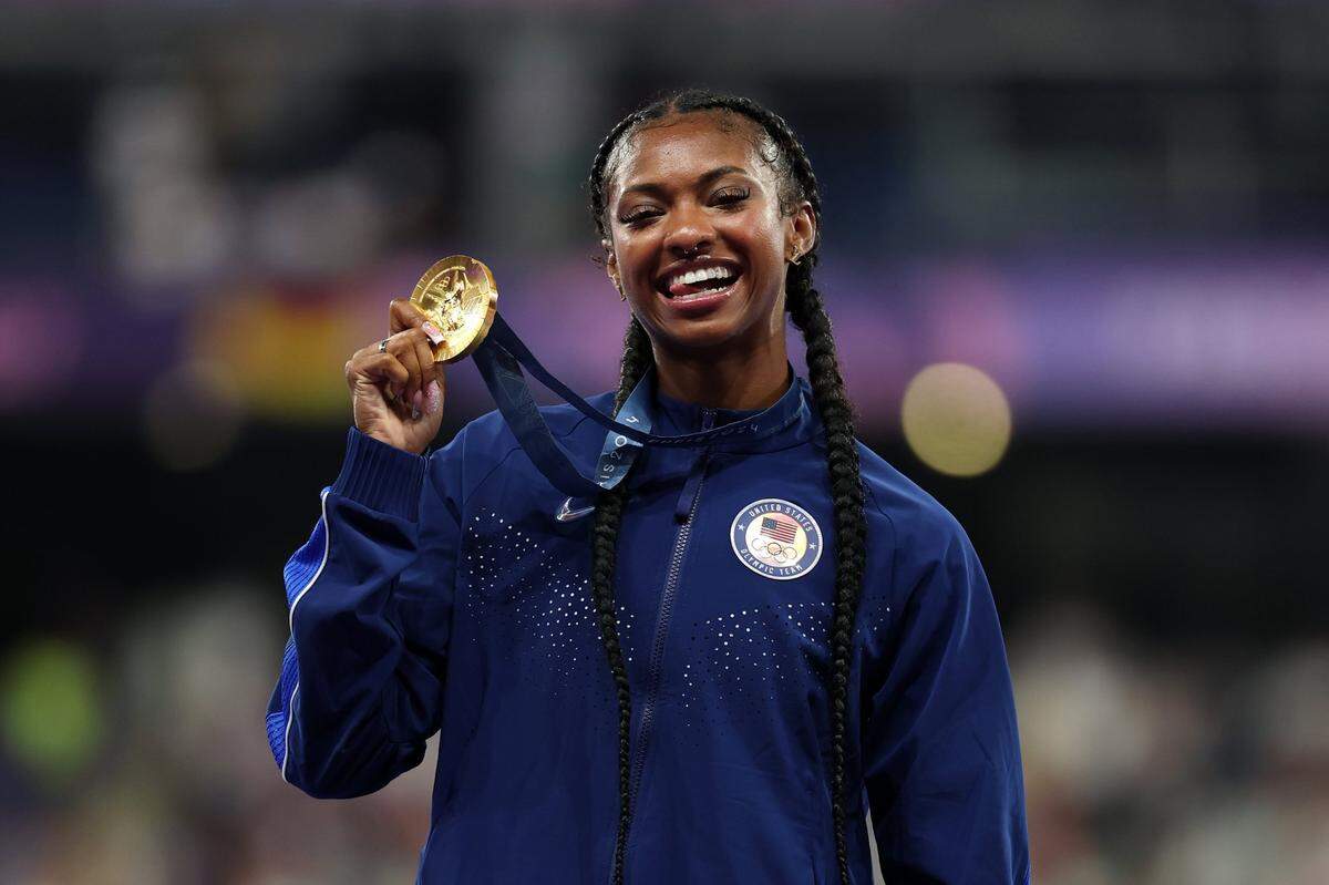 Former Kentucky Wildcats track and field star Masai Russell celebrated on the podium after receiving the Olympic gold medal for winning the women’s 100-meter hurdles in Paris, France.