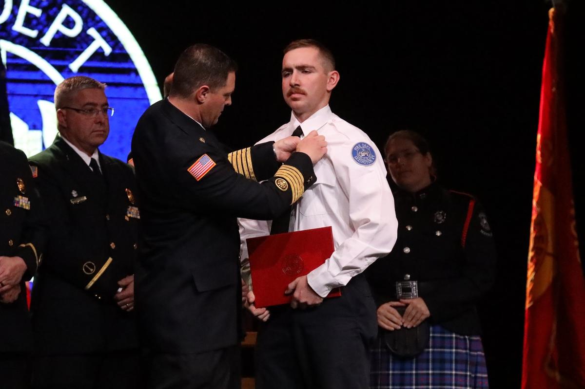 Jacob Hicks, member of the 69th graduating class of Lexington’s probationary firefighters as well as a military member soon to be deployed for a year, received his badge as a probationary firefighter on stage during the Fire Recruit Graduation at LexCity Church, December 3, 2021.