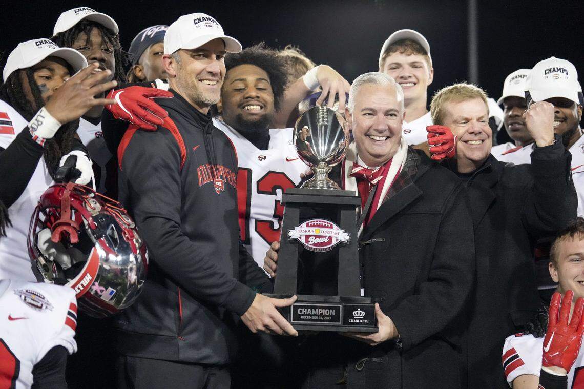 Western Kentucky head coach Tyson Helton holds the trophy with school president Tim Caboni after the Hilltoppers beat Old Dominion in the Famous Toastery Bowl at Charlotte, North Carolina.