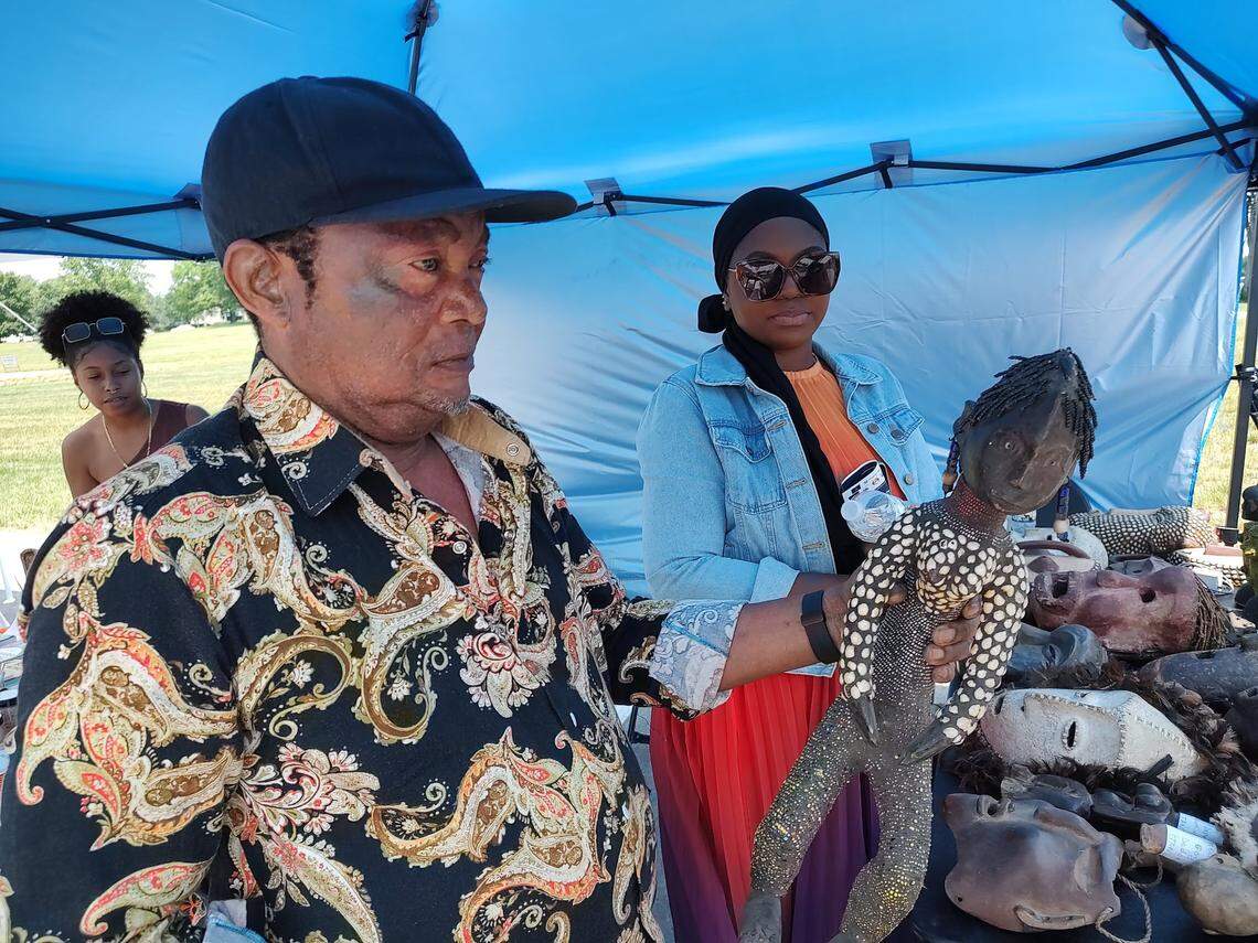 Dieudonne Makonga and his daughter, Aisha Makonga, displayed ceremonia figures and masks at Swahili Day in Lexington, Ky., June 3, 2023.