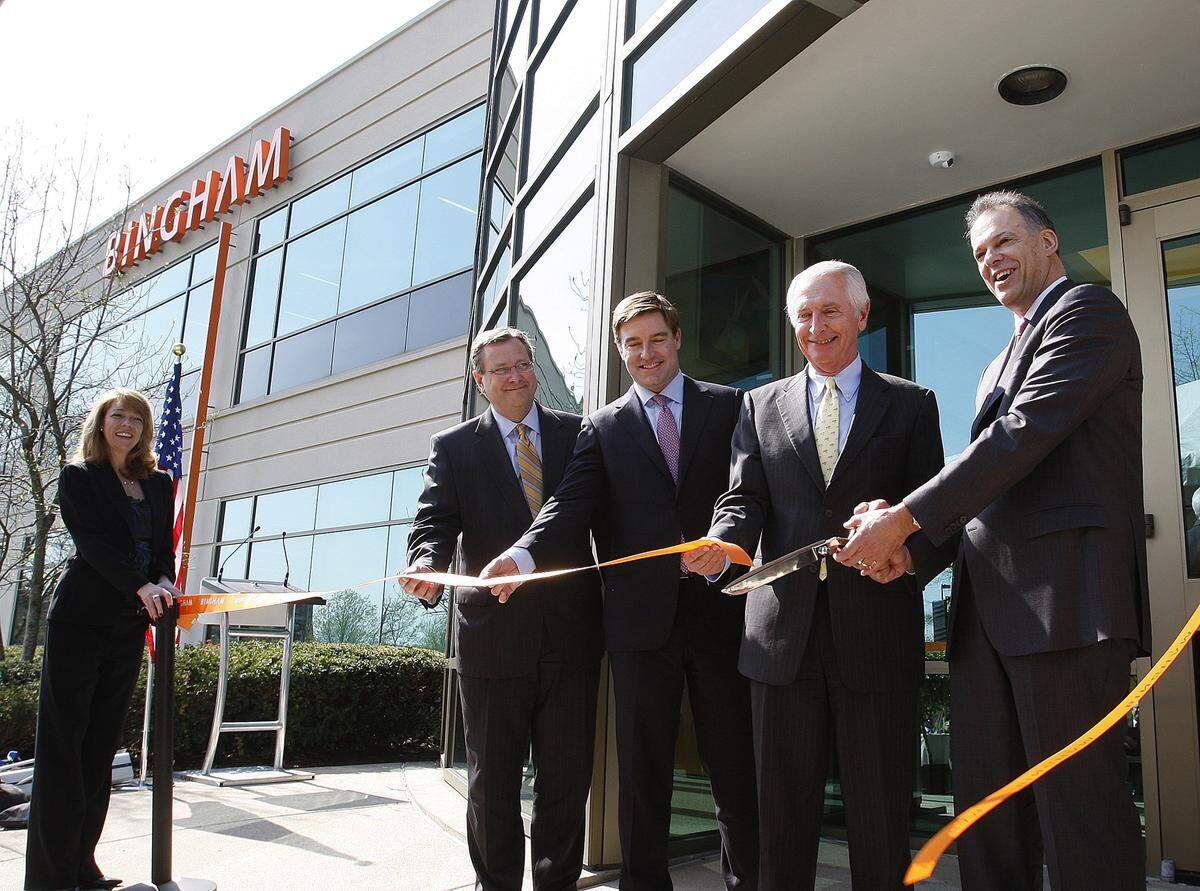 Bob Quick, president of Commerce Lexington, and Attorney General Jack Conway look on as Gov. Steve Beshear and Bingham CEO Jay Zimmerman cut the ribbon at the grand opening of the Bingham Global Services Center in Coldstream Research Park in Lexington April 18, 2012. Photo by Matt Goins
