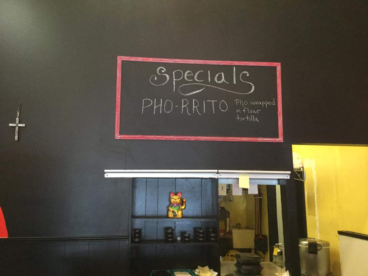 A sign at The Wok advertises the special, the “pho-rrito,” like a bowl of pho soup in a tortilla, owner Hoang Duong Jr. said.