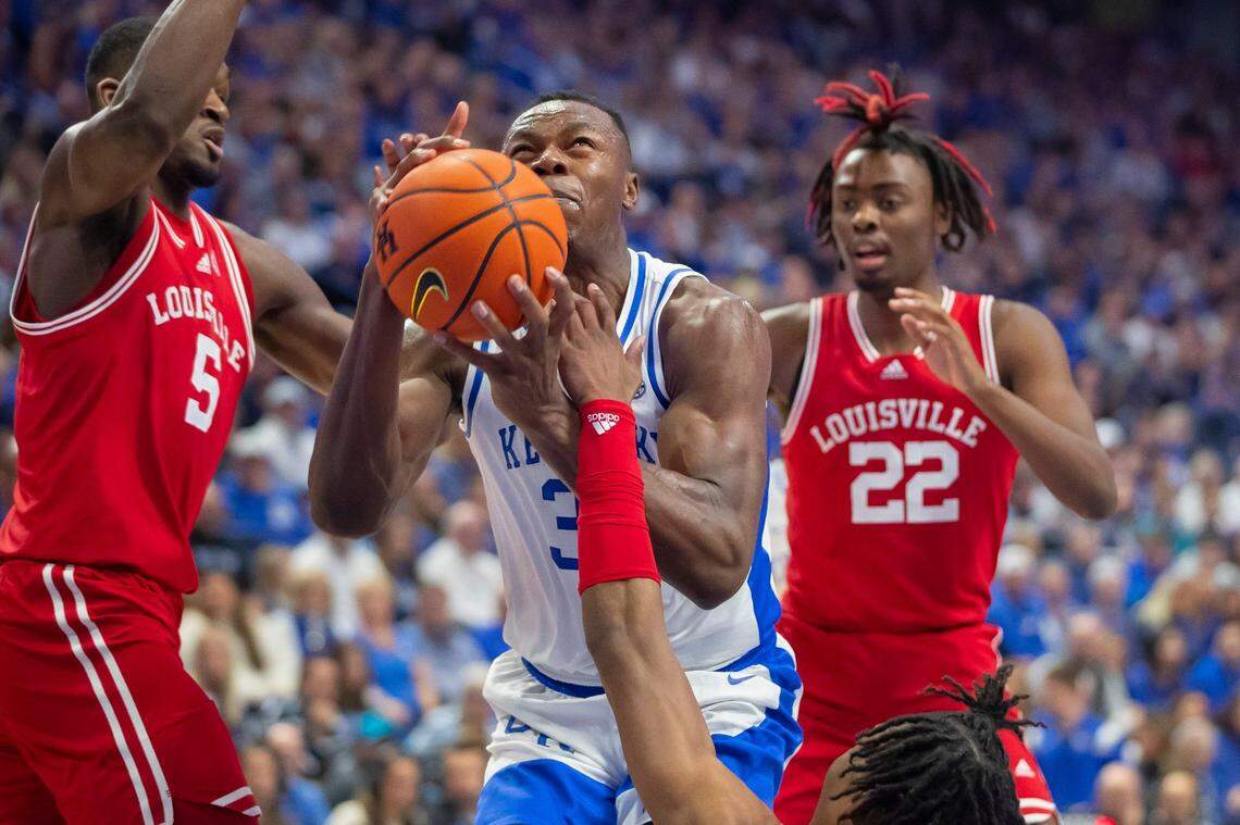 Kentucky Wildcats forward Oscar Tshiebwe (34) shoots the ball in front of Louisville Cardinals forward Brandon Huntley-Hatfield (5) and Louisville Cardinals forward Kamari Lands (22) during a game at Rupp Arena in Lexington, Ky., on Saturday, Dec. 31, 2022.