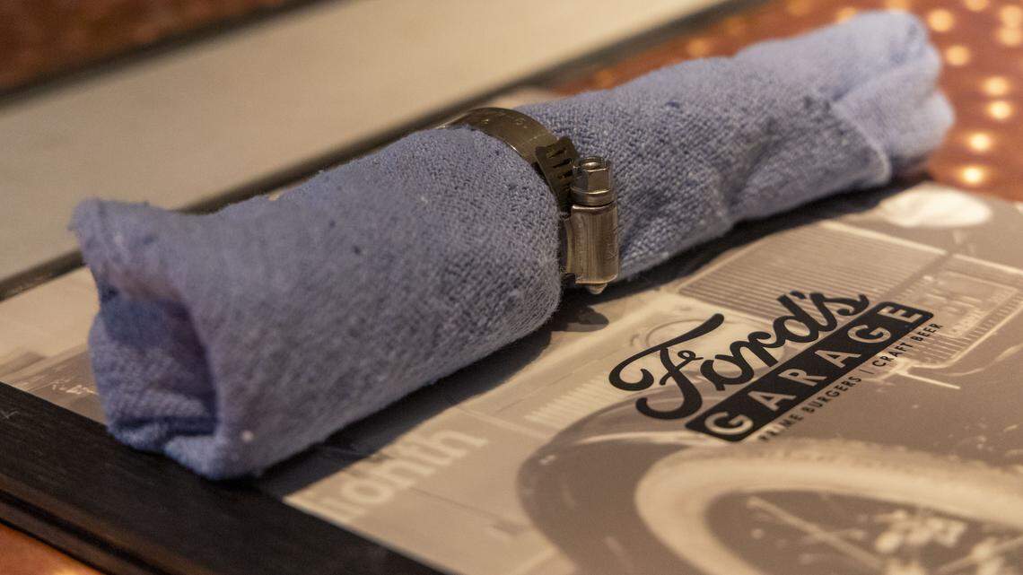 Napkins are blue shop towels at Ford’s Garage, photographed Tuesday, Nov. 4, 2025, in Lexington, Ky. The new Lexington restaurant transports diners back to a 1920s service garage with details like bathroom sinks crafted from tires and servers wearing mechanic shirts.