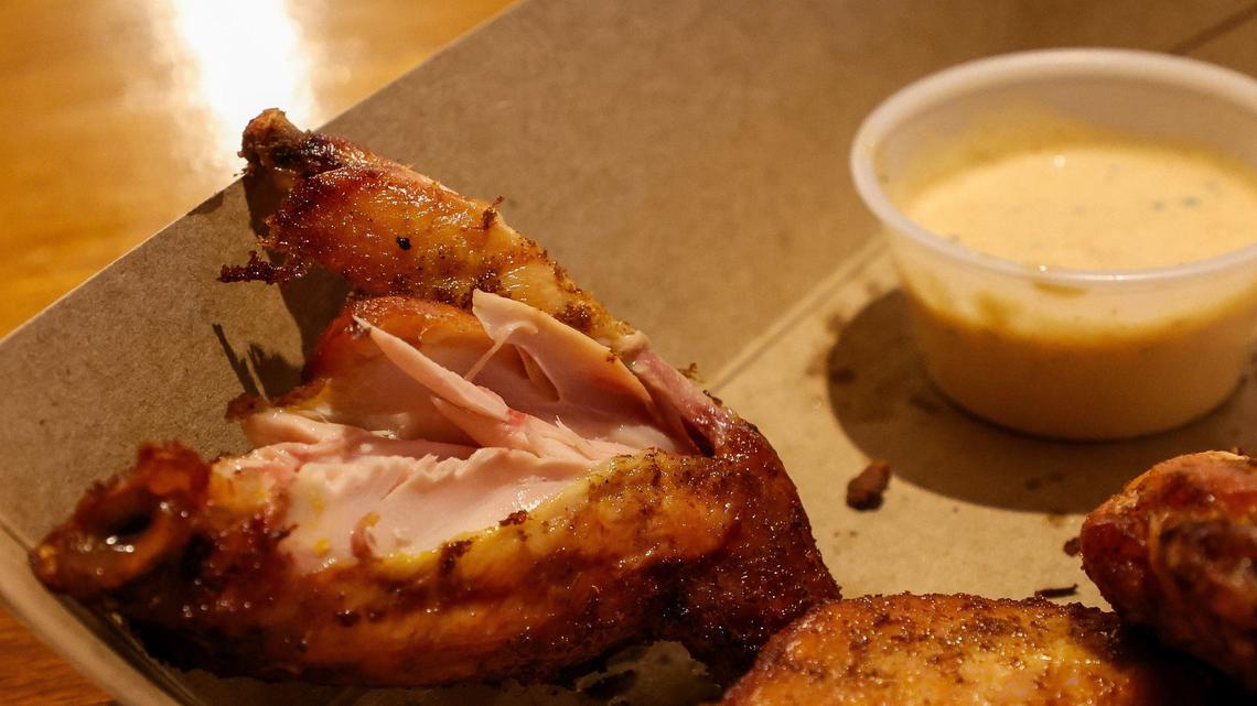 A smoked chicken wing, split open, showing the slightly pink smoked meat from Double H BBQ. The wings get a dry rub during smoking but do not have a salty spicy flavor to them. A lot of the flavor comes the the overnight marinating owner Bill Hanley says.