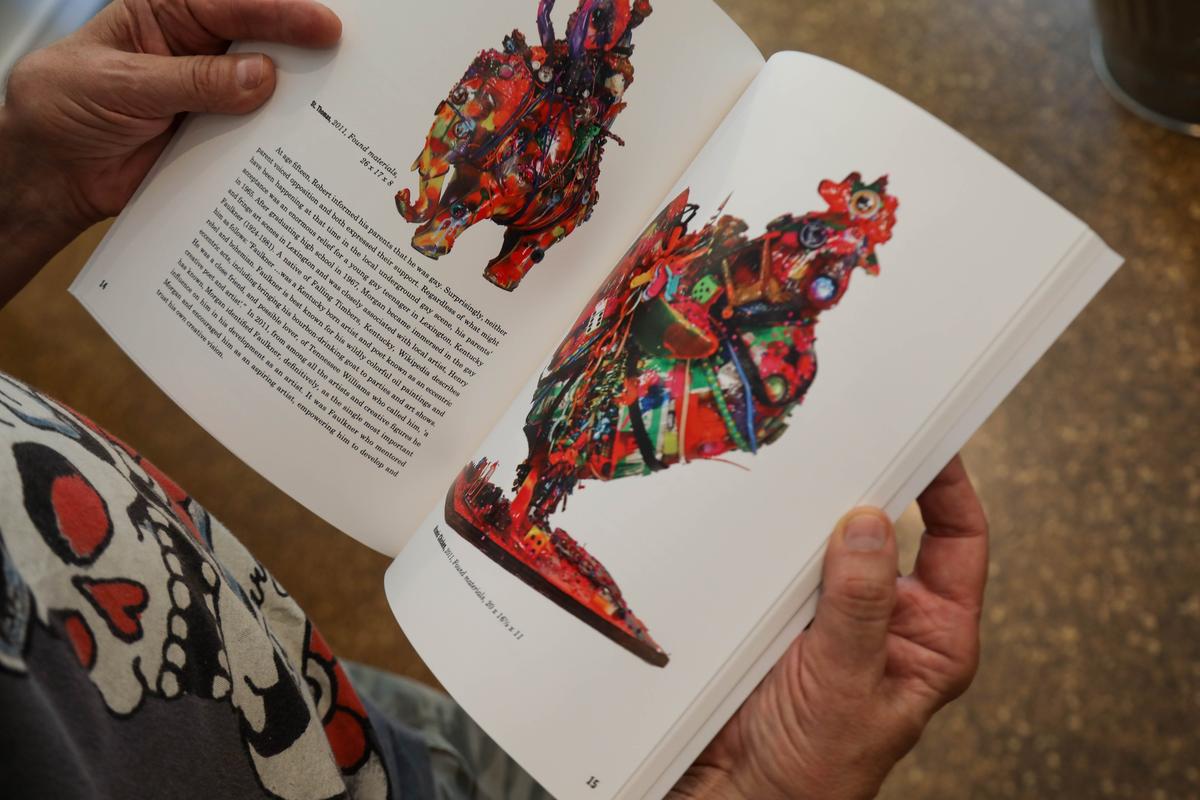 Robert Morgan flips through a book containing his sculptures, which he's been crafting from found objects since he was a child.