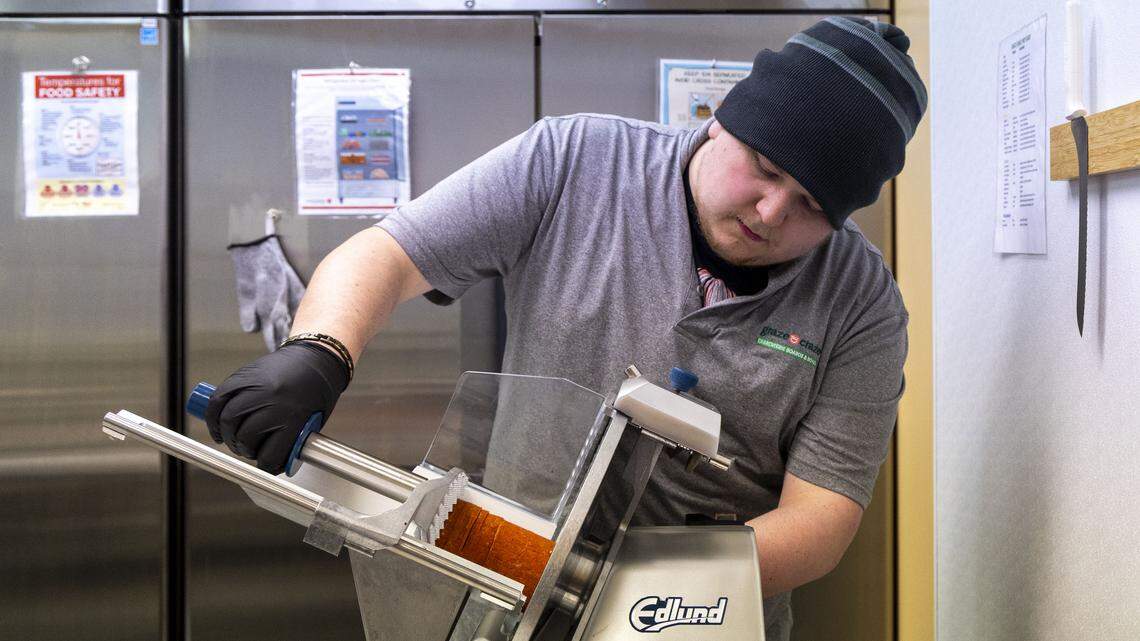 Mathew Poynter slices meat at Graze Craze, a new Lexington charcuterie board store now open at 3090 Old Todds Road. All the meats and cheeses are sliced in-house at the store. Photographed Wednesday, Dec. 10, 2025, in Lexington, Ky.