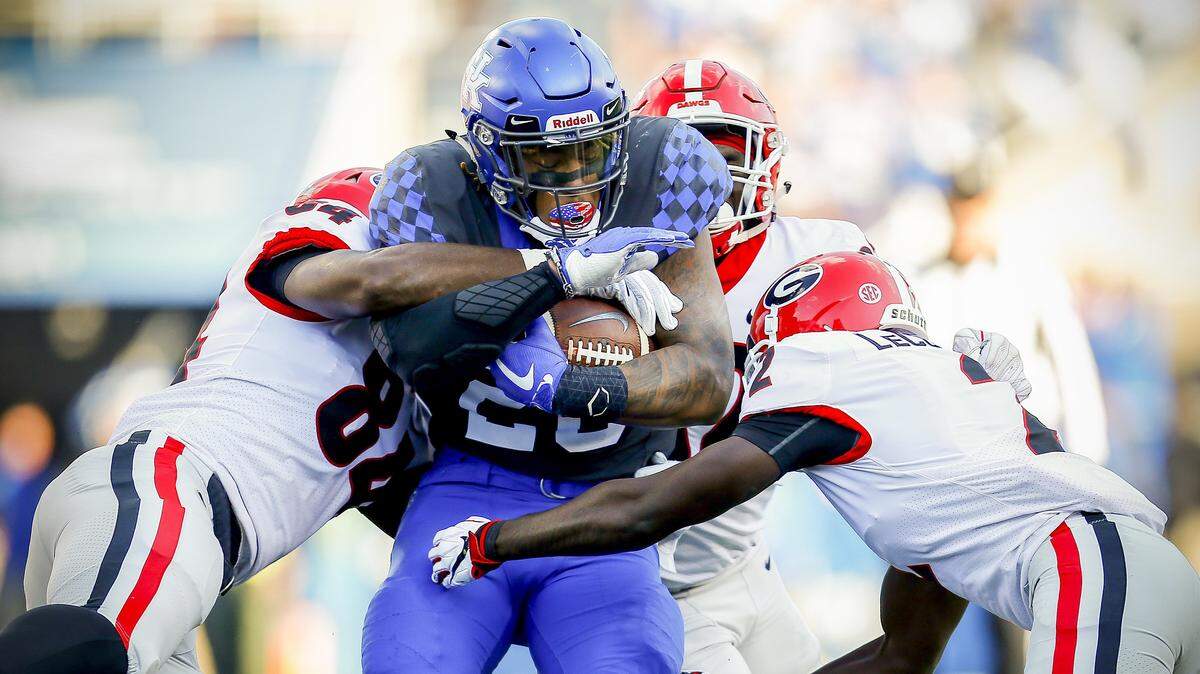 Kentucky running back Benny Snell (26) was stopped by Georgia’s Walter Grant, left, Monty Rice and Richard LeCounte. Coaches hope to get the junior and the Cats’ ground game back on track this week at Tennessee.