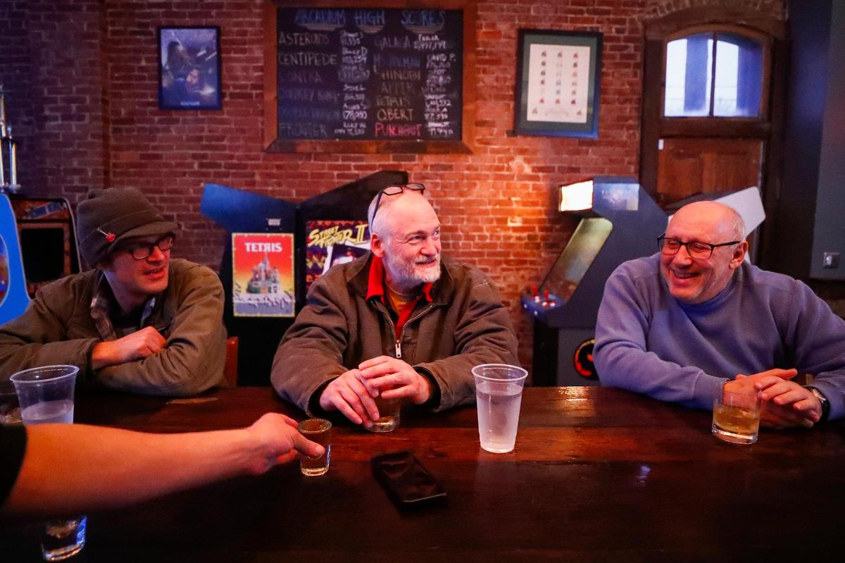 Jamie Hoffman, from left, Phillip Smyth, and Jeff Shaver, all of Lexington, gather for a drink Feb. 6 at Arcadium, which will offer pub food and bar-friendly snacks in the spring.
