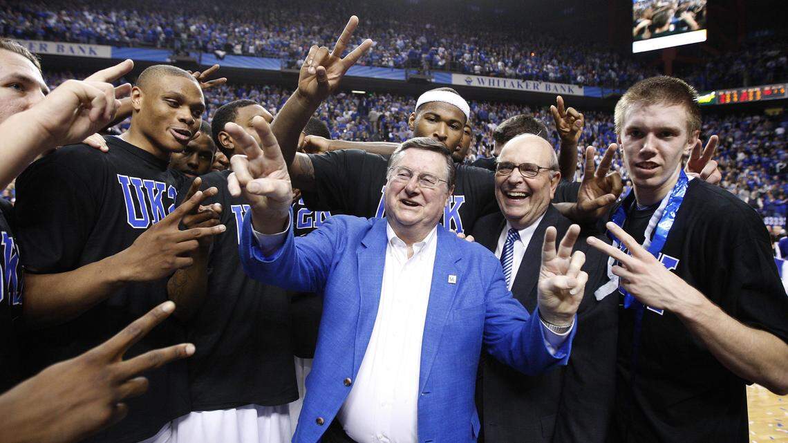 Former Kentucky basketball coach Joe B. Hall, center, with Herky Rupp, Adolph Rupp's son, celebrated UK's 2,000th win with the players on Dec. 21, 2009.