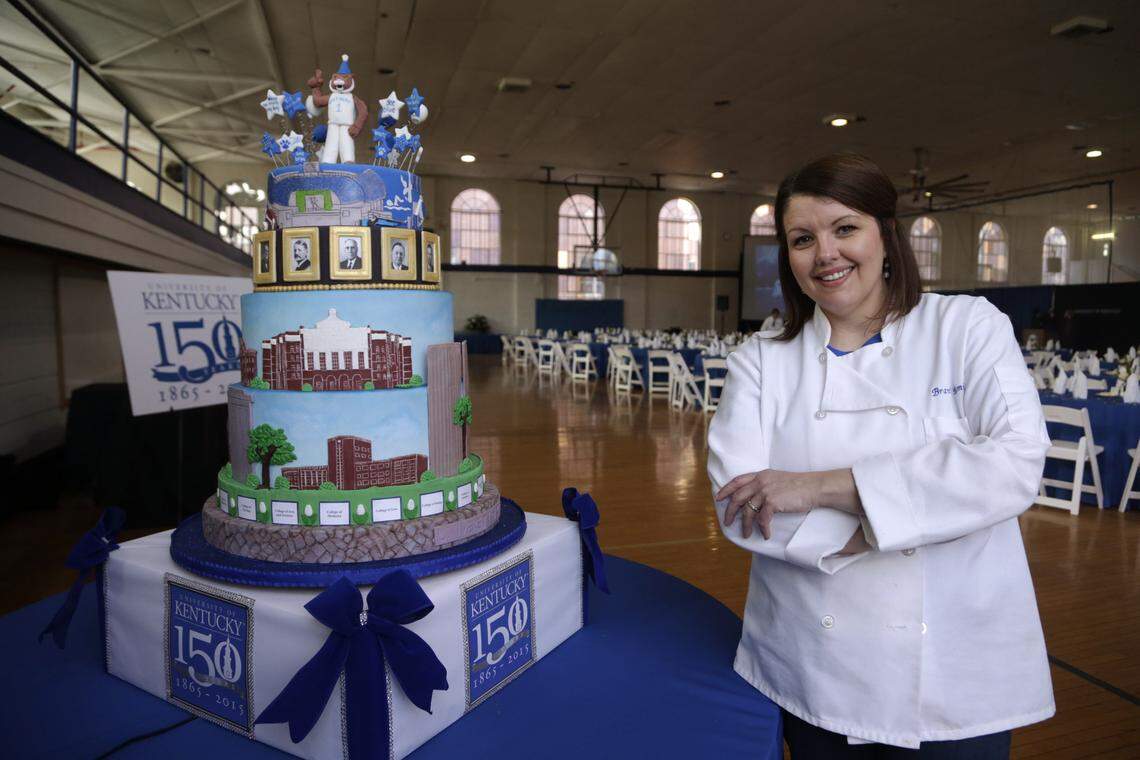 Brandi Romines posed with her decorative cake in Alumni Gym for a 2015 luncheon in Lexington. The multi-layered cake made for UK’s sesquicentennial events features national championship banners, iconic buildings new and old, and is topped with a wildcat mascot. Romines is going to be on a new Netflix baking streaming show.
