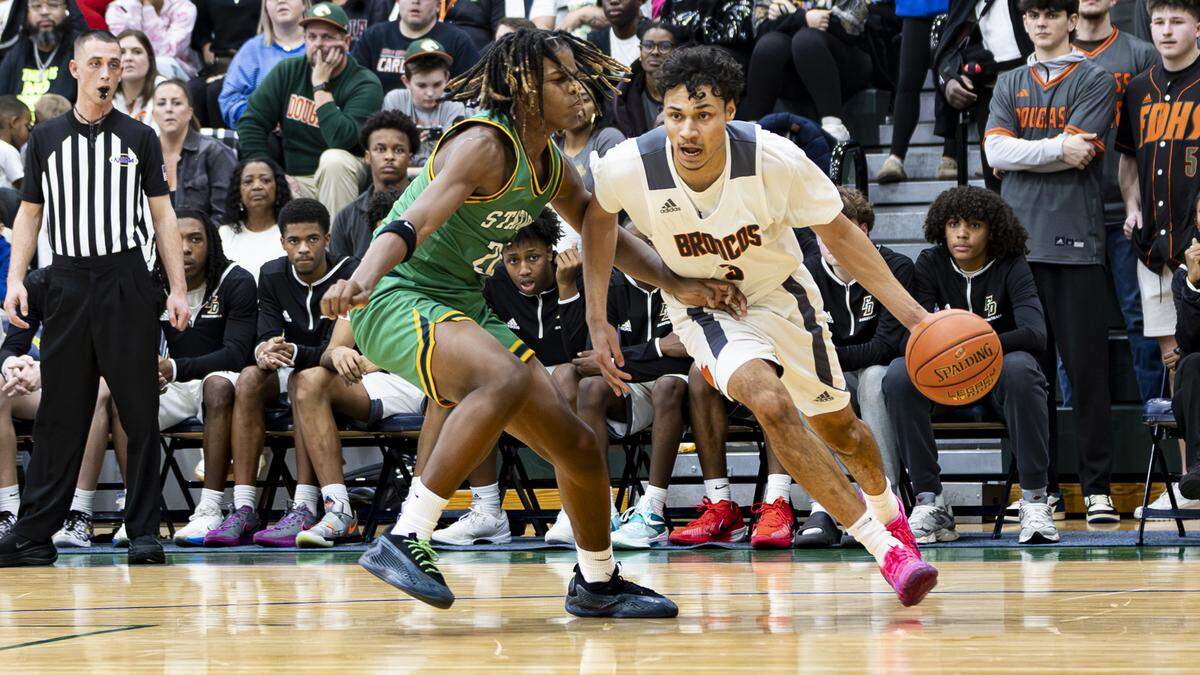 Frederick Douglass’ DeMarcus Surratt, right, drives the baseline against Bryan Station’s Ethan Owens during the boys 42nd District Tournament championship game at Bryan Station High School on Friday.