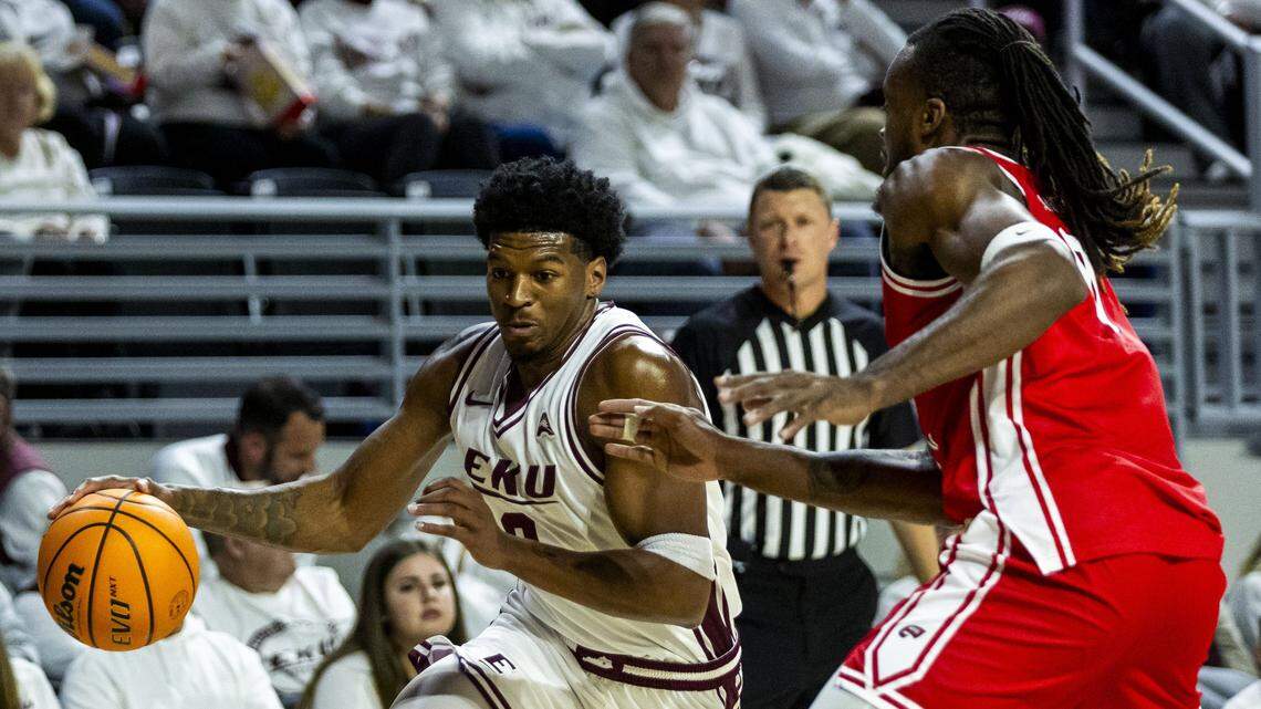 Eastern Kentucky forward Jalen Cooper (8) drives on Western Kentucky forward Bryant Selebangue (0) during the Hilltoppers’ win Monday at Baptist Health Arena at Alumni Coliseum in Richmond.