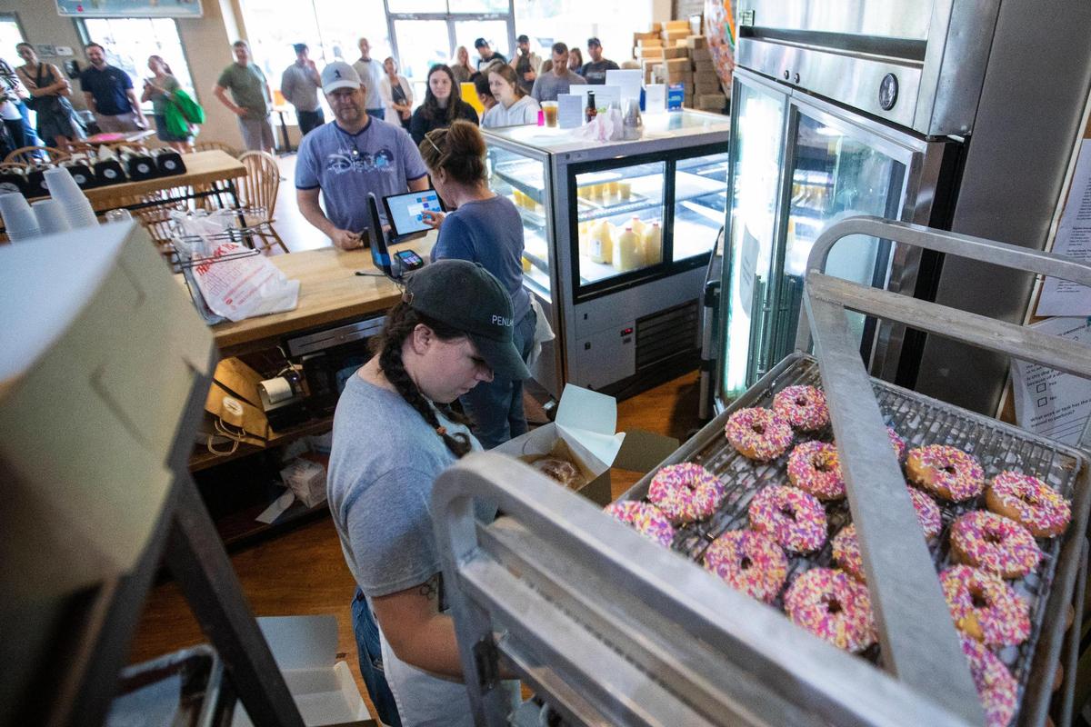 Employees box up baked goods for patrons who lined up around the corner of South Ashland and Main Street to try and purchase something on the last day of business for Magee’s Bakery in Lexington, Ky., Saturday, May 13, 2023. Some people waited in line over two hours.
