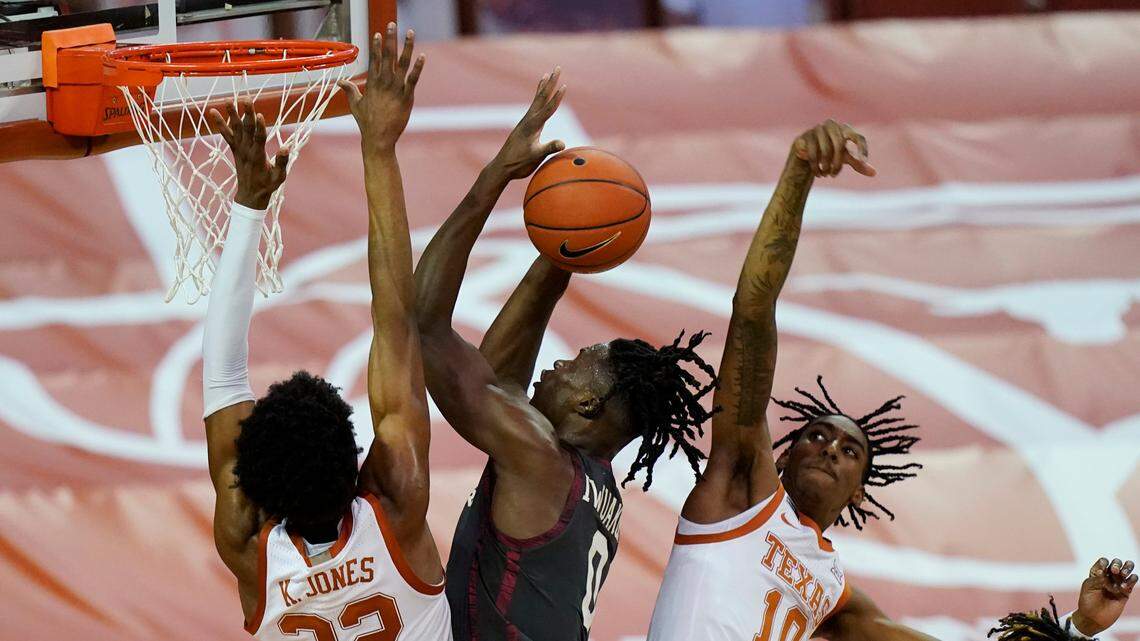 Oklahoma’s Victor Iwuakor (0) is pressured by Texas’ Kai Jones (22) and Donovan Williams (10) during a game in Austin, Texas, last season. Both schools are reportedly negotiating a move to the SEC.