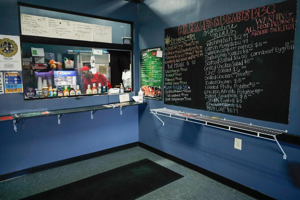 Robert Williams, of Lexington, Ky., executive chef at Mr. Krabs & Bean’s BBQ works behind the restaurant’s order window in Lexington, Ky., Thursday, Nov. 19. 2020.