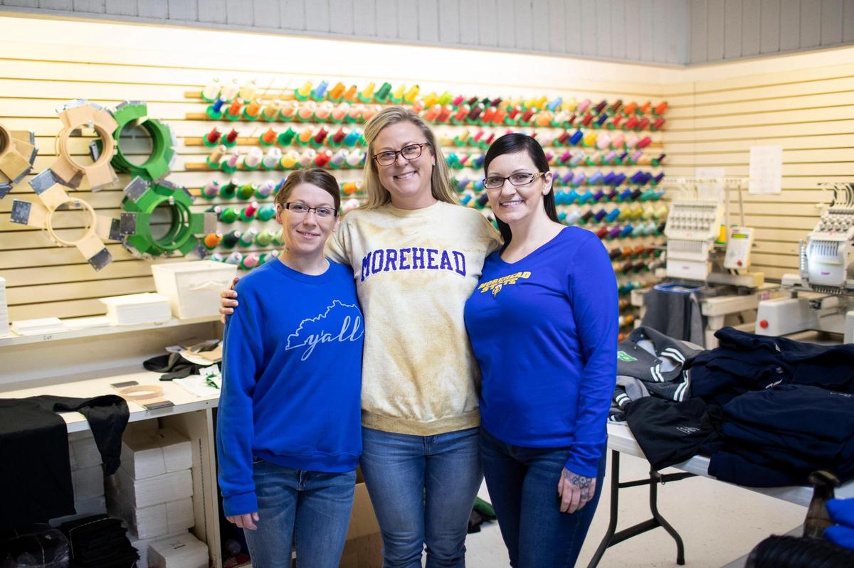 Brandy Moore (left) and Deidra Stearns with Kari Flanders (center) the owner of Holbrook’s Embroidery Plus in Morehead, Ky., on Tuesday, November 22, 2022.