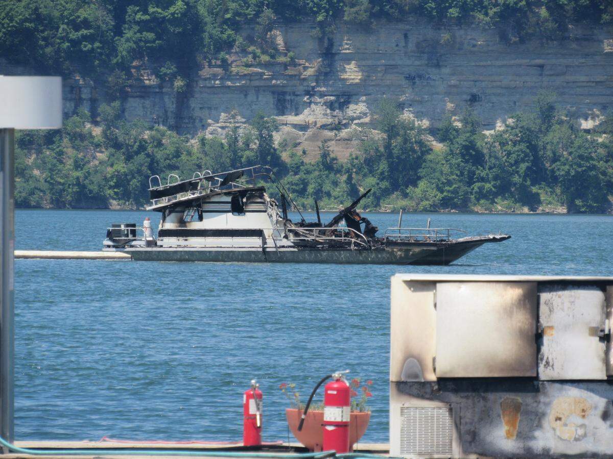 A boat damaged in a fire at Conley Bottom Resort on Lake Cumberland on May 20, 2019 floats at the marina. The fire destroyed the marina restaurant, store and office, but the only boats destroyed belonged to a business.
