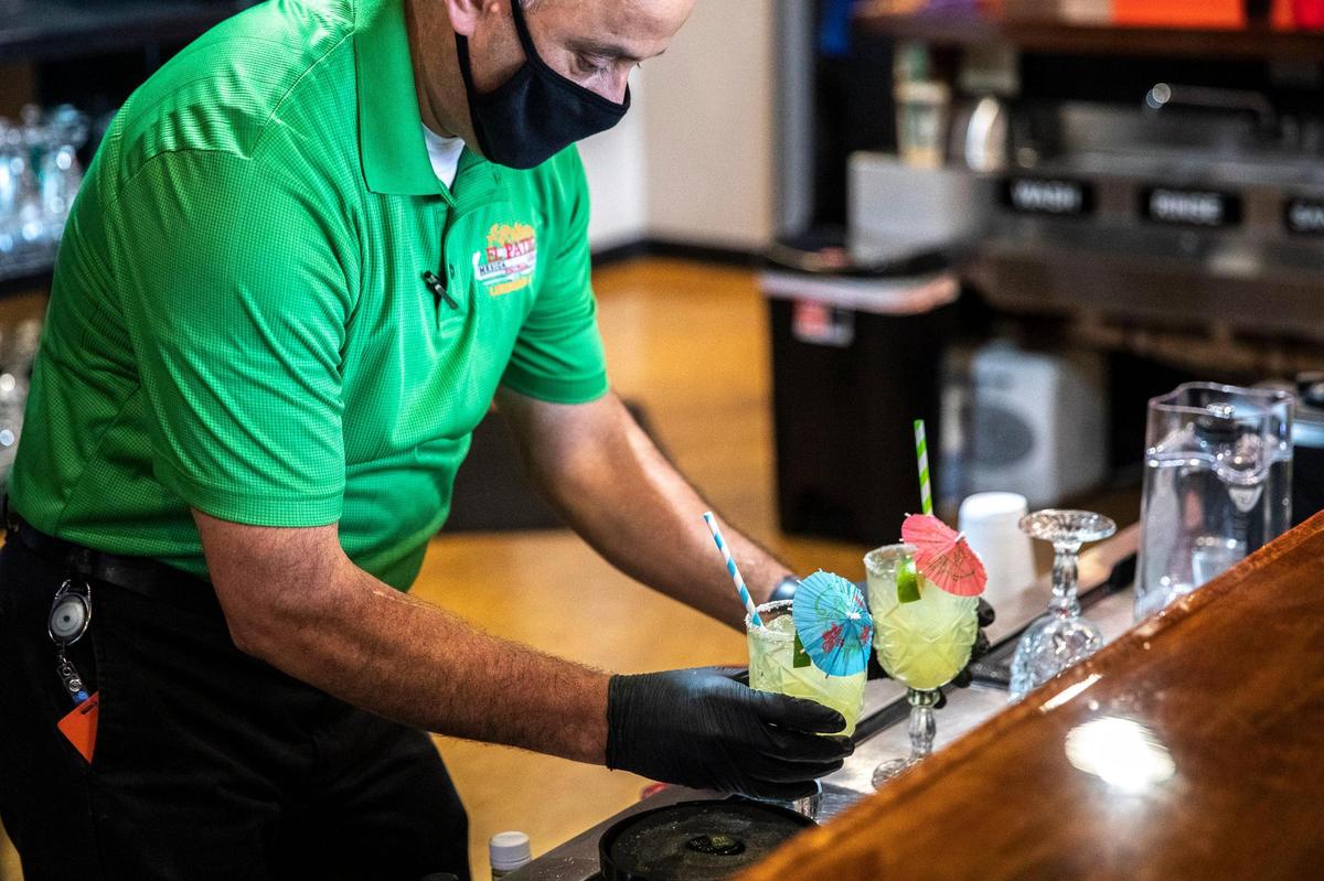 Julio Lopez prepares two margaritas at El Patio. The restaurant also has bottled beer.
