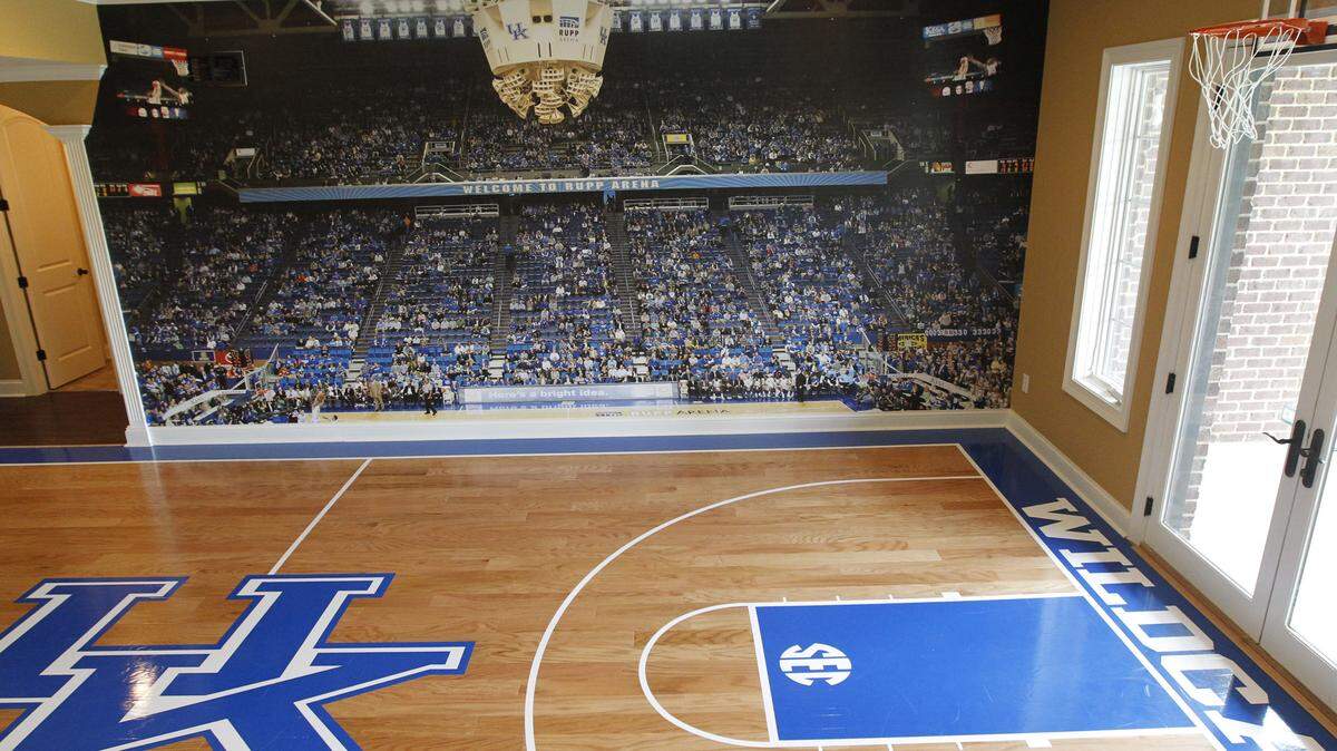 In the basement of J.D. and Meg Quarles' home in Frankfort is a basketball court complete with UK floor decals and a wall-sized photo of Rupp Arena that includes J.D. and his son in the stands.   