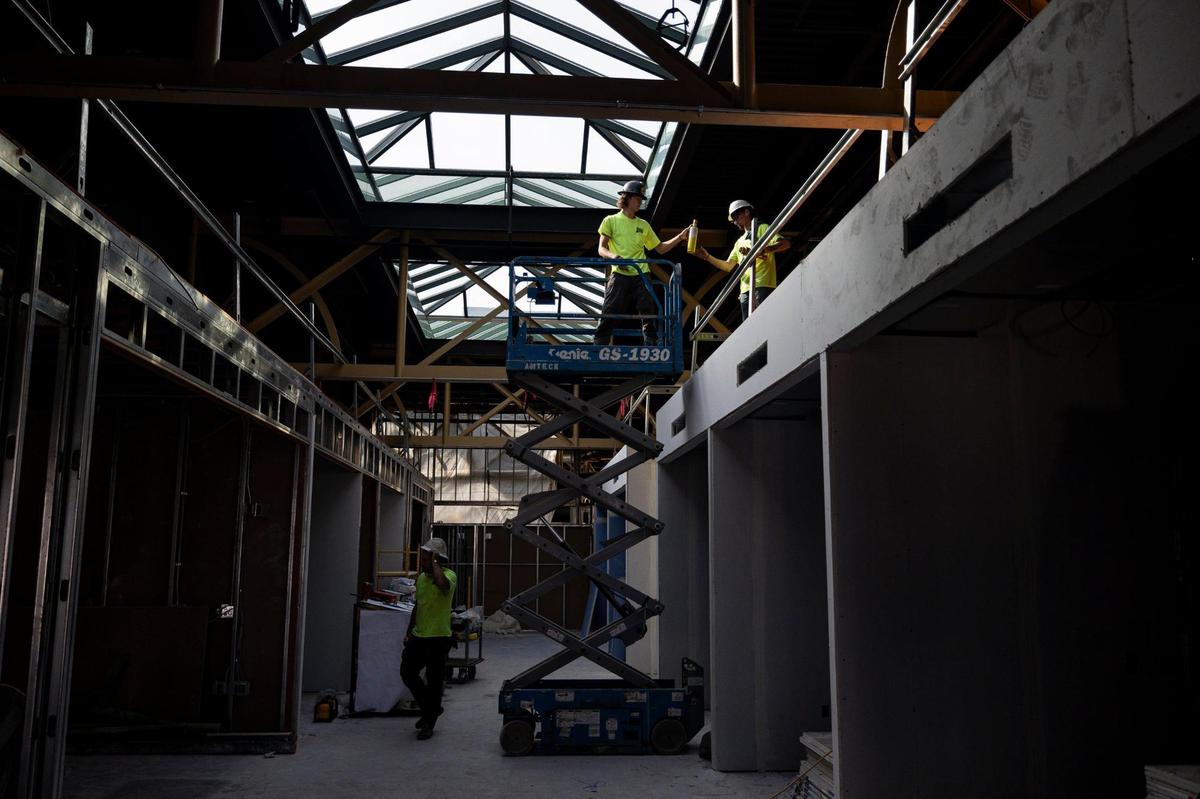 Construction workers pass items between each other while working on the third floor of the building on Friday, June 20, 2025, at 325 Main Street in Lexington, Ky.