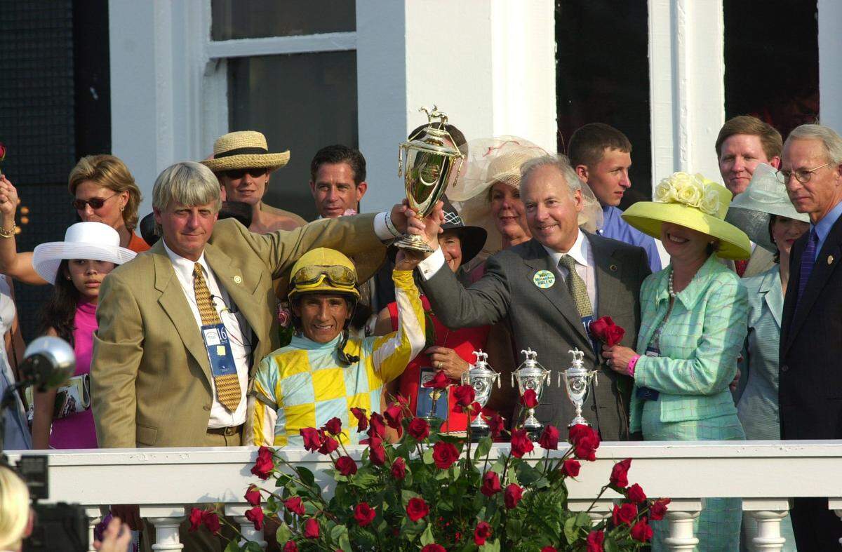 Trainer John Ward, left, jockey Jorge Chavez and owners John and Debbie Oxley hold up the trophy in the winner’s circle after Monarchos’ 4 3/4-length victory in 2001.
