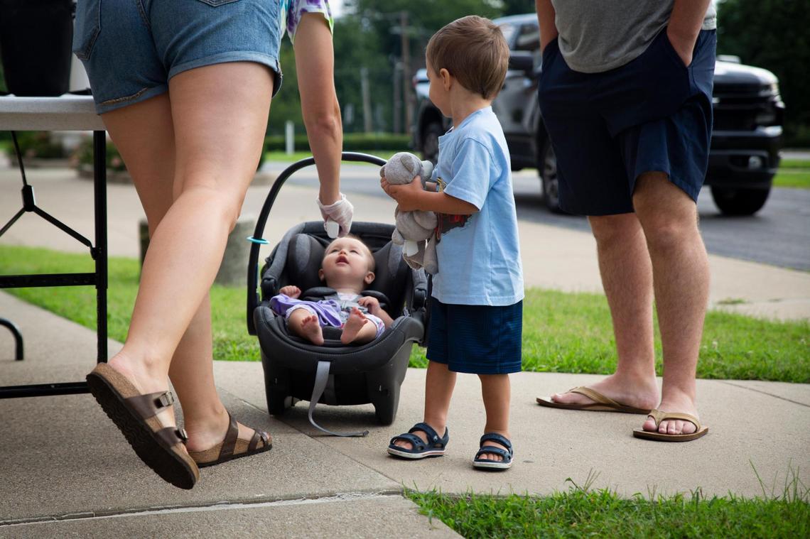 Rory Haney, 8 months, has her temperature taken by Central Baptist Church Childcare Center employee Alisha Brock while her brother Jaxson, 2 and a half, and her father stand nearby in Lexington, Ky., on Friday, August 7, 2020. Brock has been employed at CBCCC for nine years. CBCCC permanently closed on Friday and is one of many childcare centers that are closing due to reasons caused by the COVID-19 pandemic.