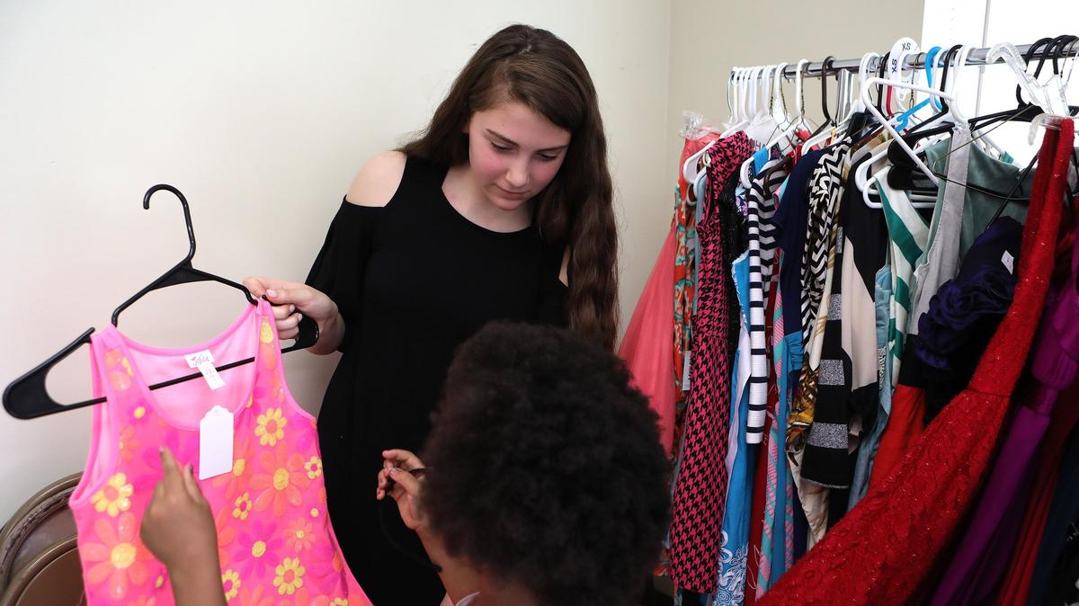Edythe J. Hayes eighth grader Grace DiNardo helped a girl select a dress Tuesday. DiNardo collected hundreds of dresses to help young girls have proper attire for upcoming graduations and proms.
